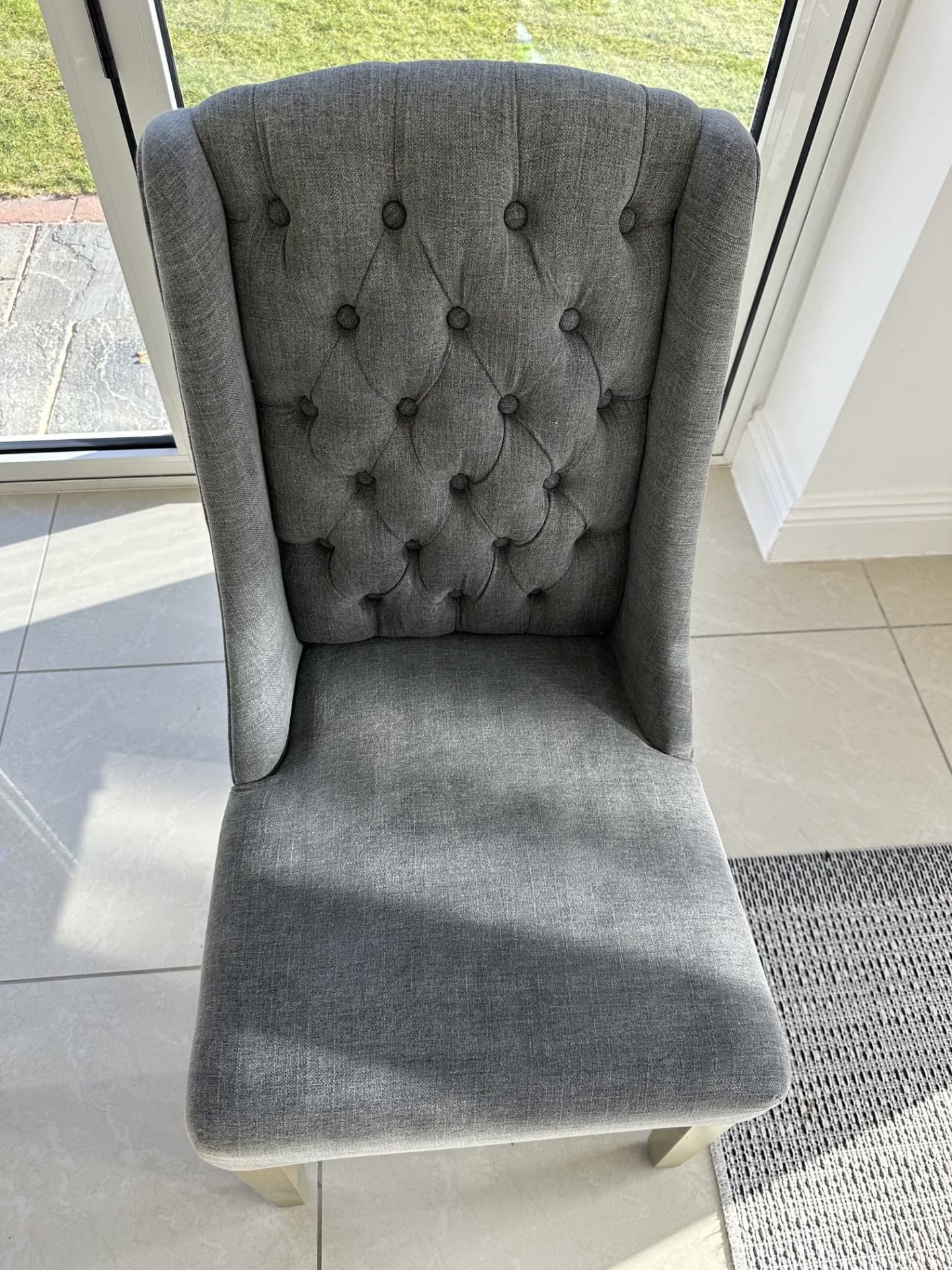 Grey tufted dining chair after professional cleaning with stains removed