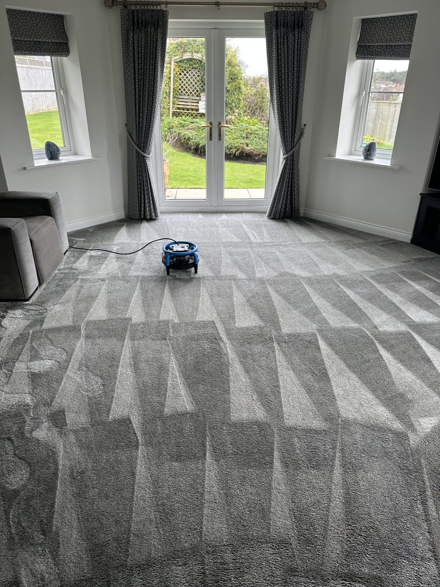 Living room carpet drying after professional cleaning with air mover in Buckinghamshire