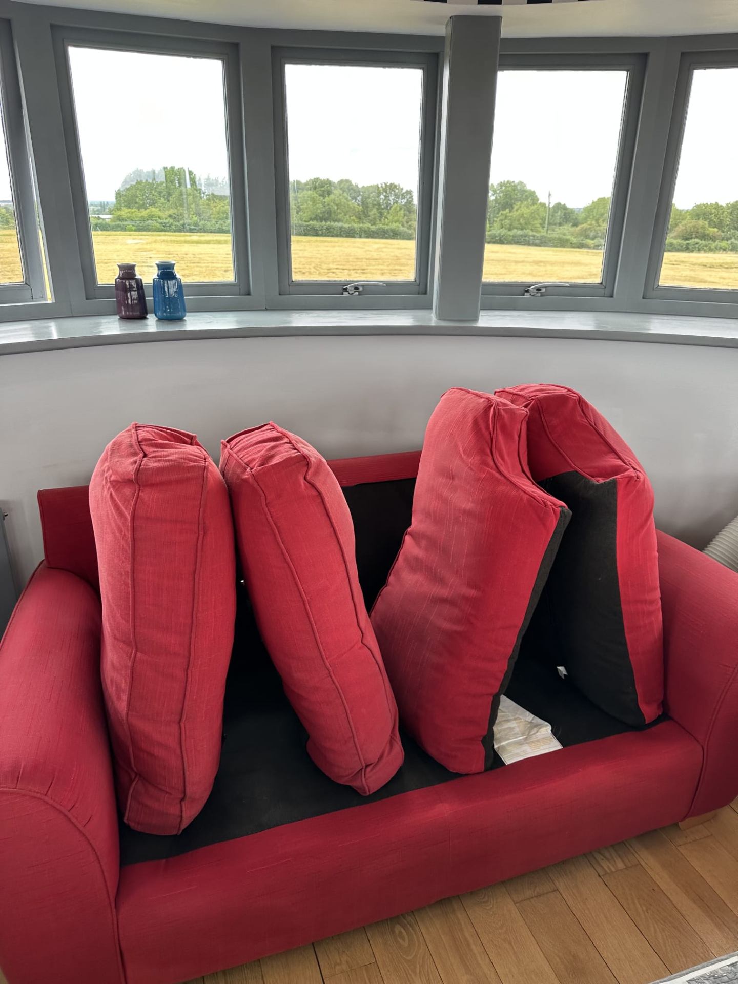 Red sofa cushions propped up during professional upholstery cleaning