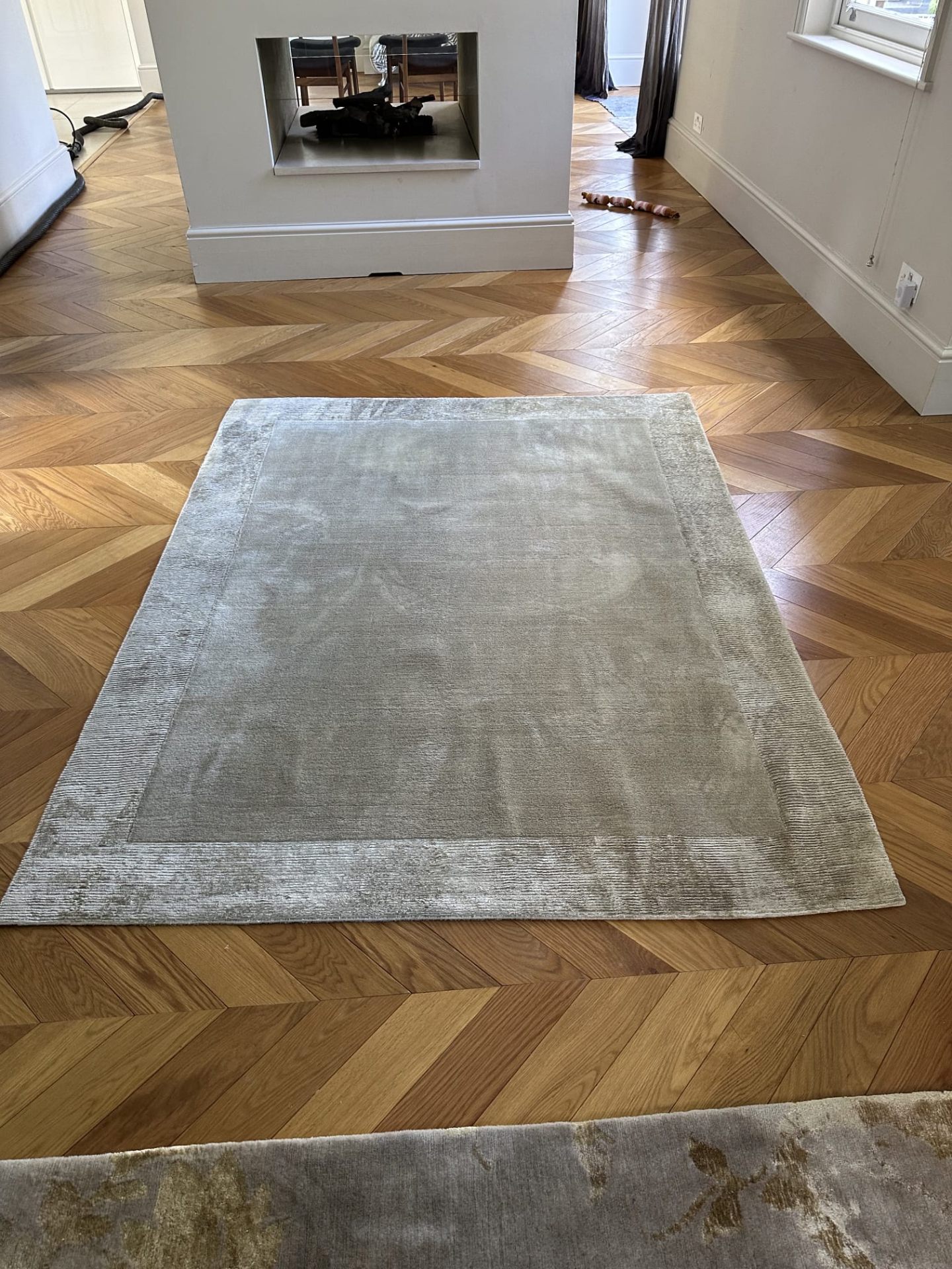 Silk blend rug professionally cleaned and restored on herringbone wood floor