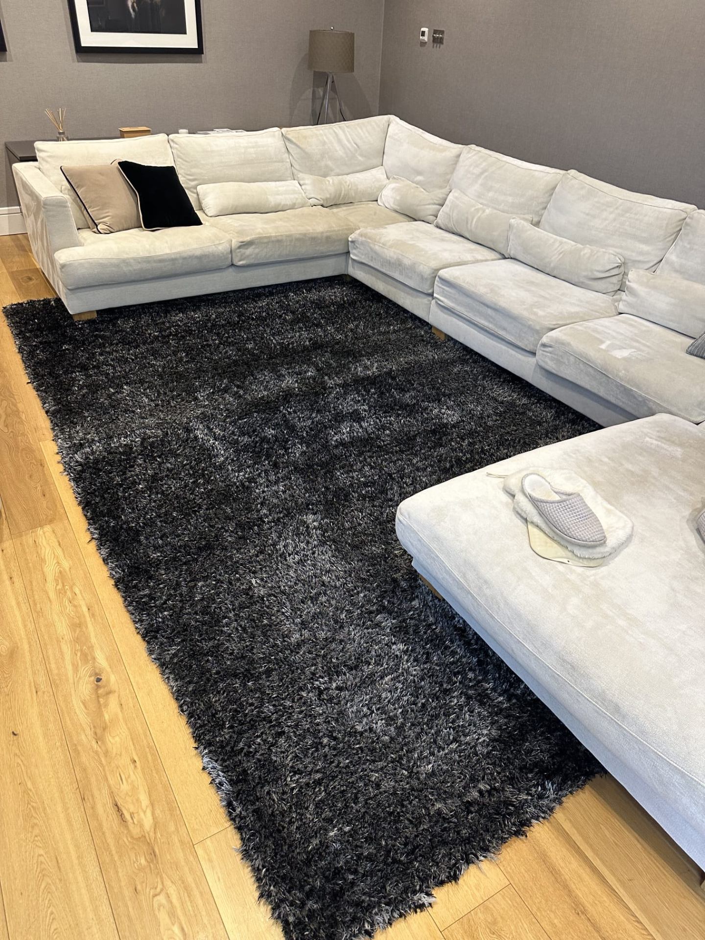 Dark shaggy rug professionally cleaned alongside white sofa in modern lounge